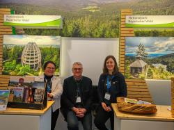 Gemeinsam präsentieren Manuela Moosbauer (v.l.) von der TI in Waldkirchen für den Landkreis Freyung-Grafenau, Kurt Joachimsthaler aus der TI in Frauenau für die Ferienregion Nationalpark Bayerischer Wald und Julia Zink für den Nationalpark Bayerischer Wald das touristische Angebot am Counter des Tourismusverbandes Ostbayern. Foto: Andrea Kralik/FNBW