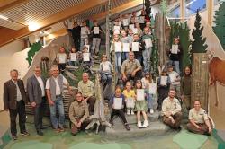 Zum Gruppenfoto stellten sich die Junior Ranger nebst Ehrengästen und Nationalpark-Rangern in der Waldwerkstatt des Hans-Eisenmann-Hauses auf. (Foto: Nationalpark Bayerischer Wald)